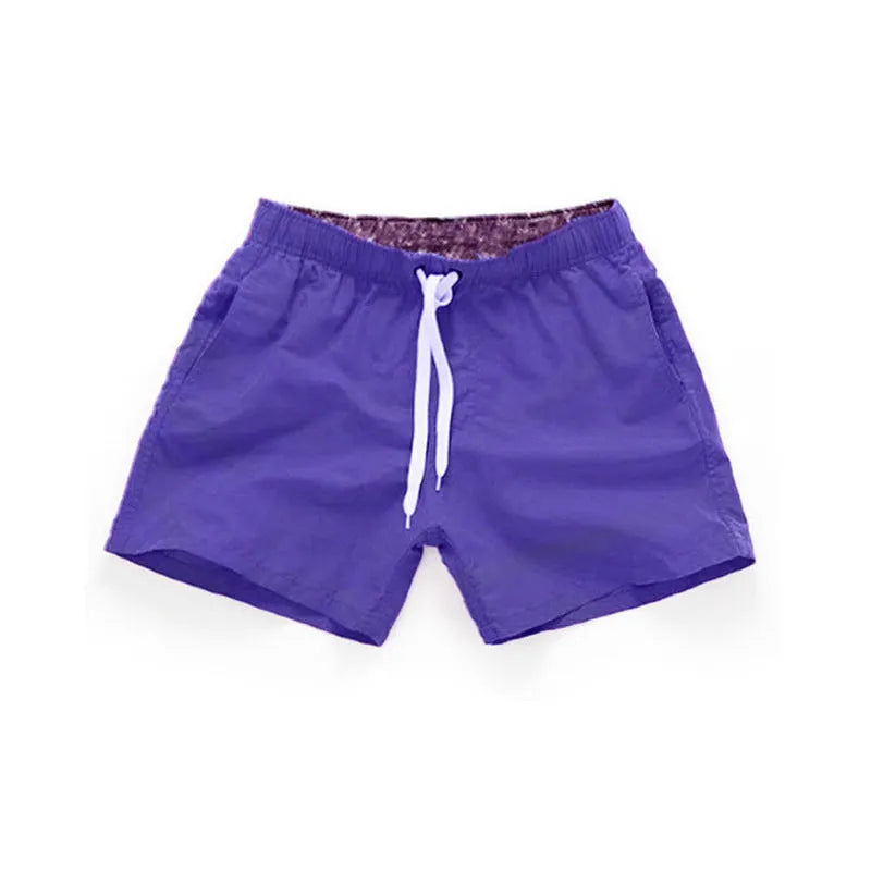 Men's straight-leg beach shorts in polyester fabric shown in a solid colour, laid flat.