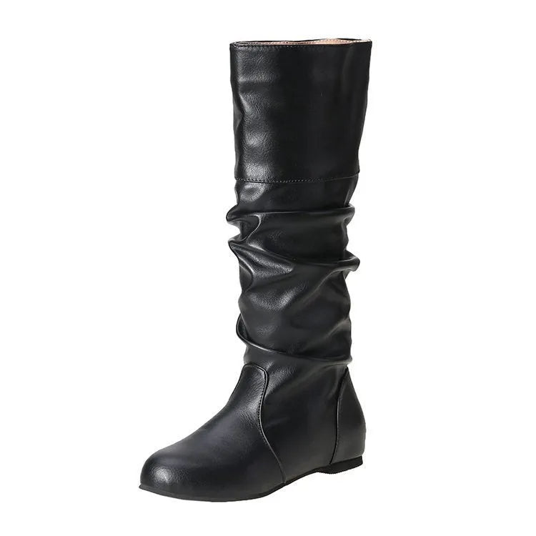 Women's flat slip-on long boots with round toe in black, shown on a foot.