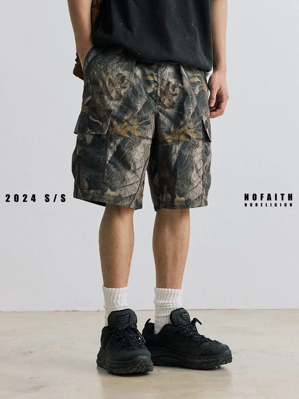Man's loose straight-leg denim shorts in black on a hanger, showing mid-rise waist and zip fly.