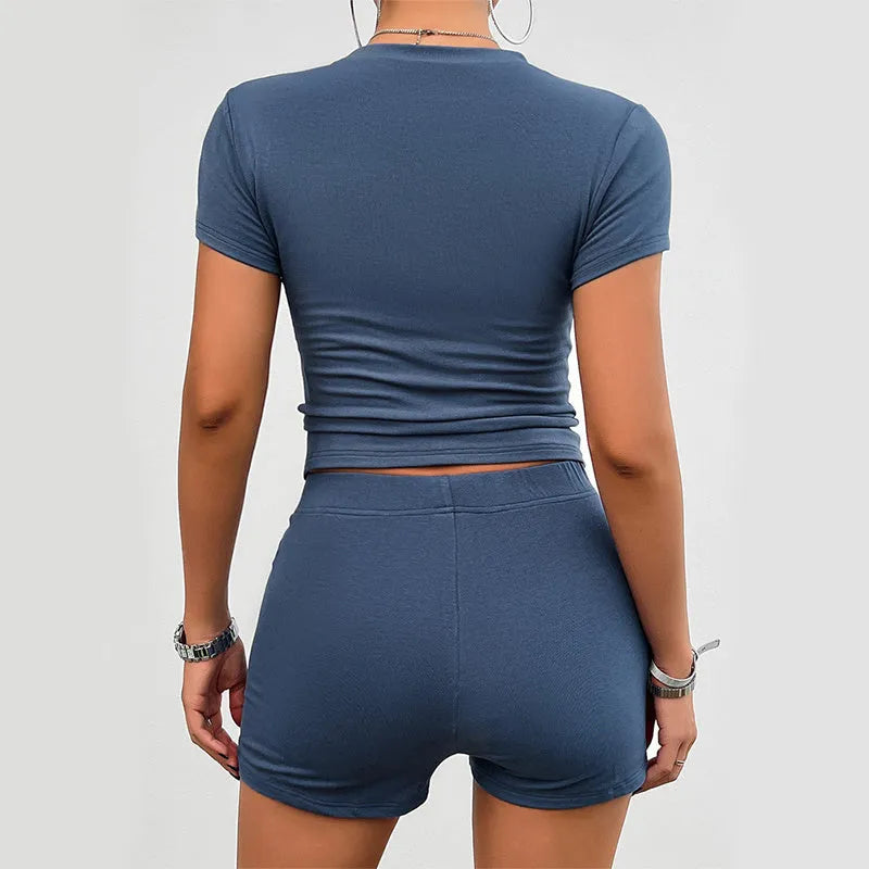 Women's solid colour slim fit sports suit set with short sleeve t-shirt and elastic waist shorts.