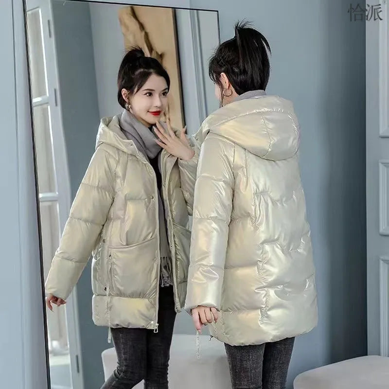A green loose-fit hooded winter jacket for women on a hanger, showing long sleeves and thick insulation.