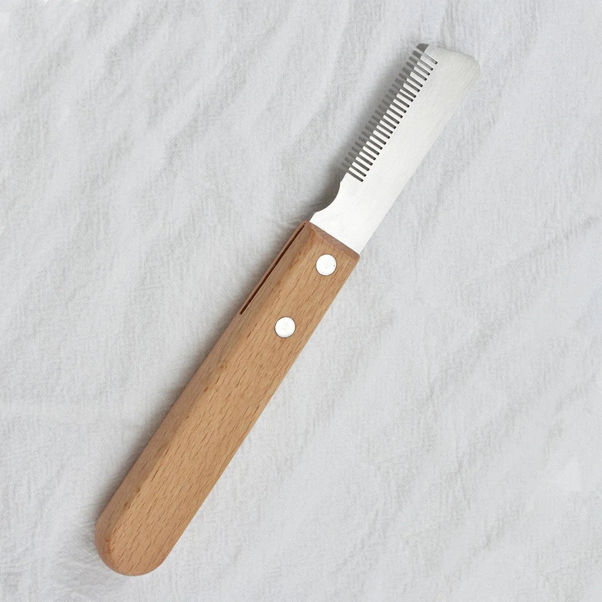 Pet stripping comb with wood handle and metal teeth for grooming long-haired dogs and cats.