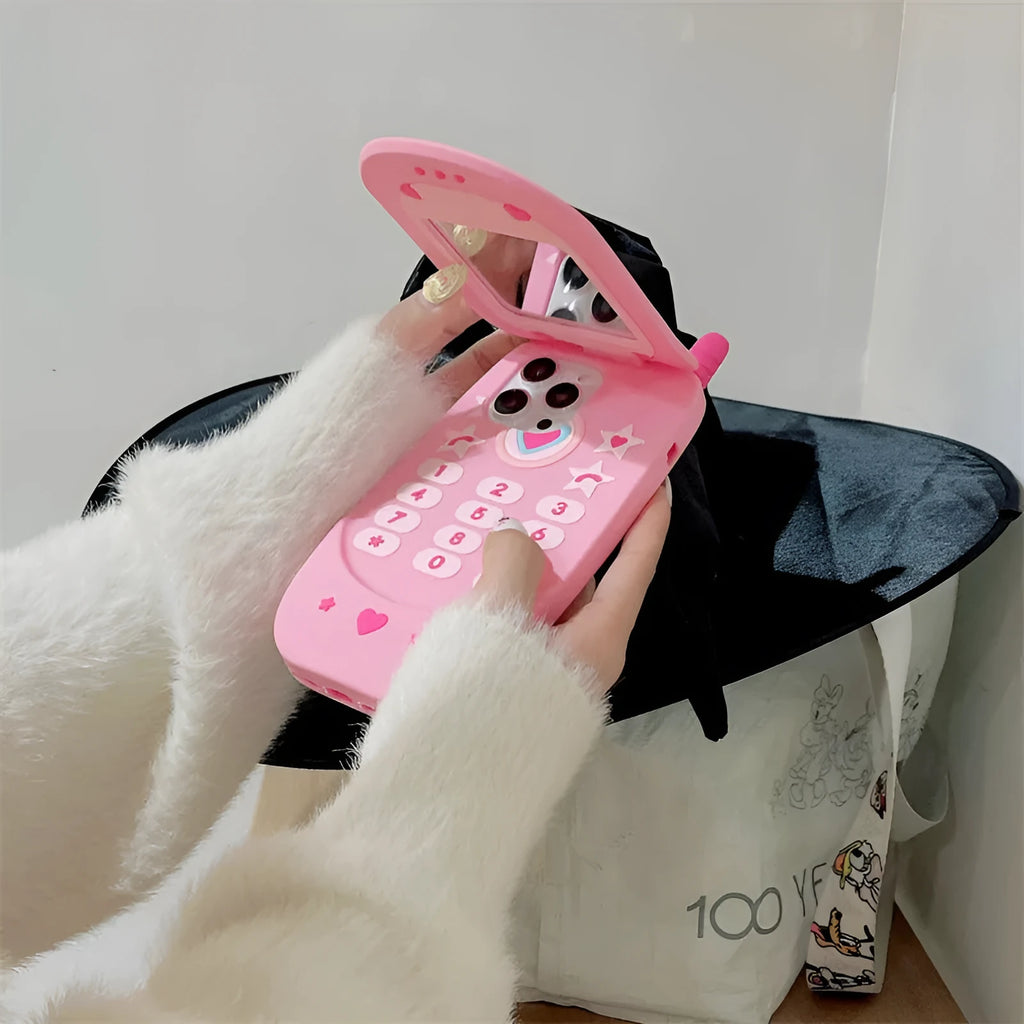 Light pink silicone flip phone case with mirror for iPhone, featuring a cute cartoon design.