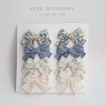 Set of eight fabric hairclips with dovetail bows in a chosen colour like beige grid dots or pink.