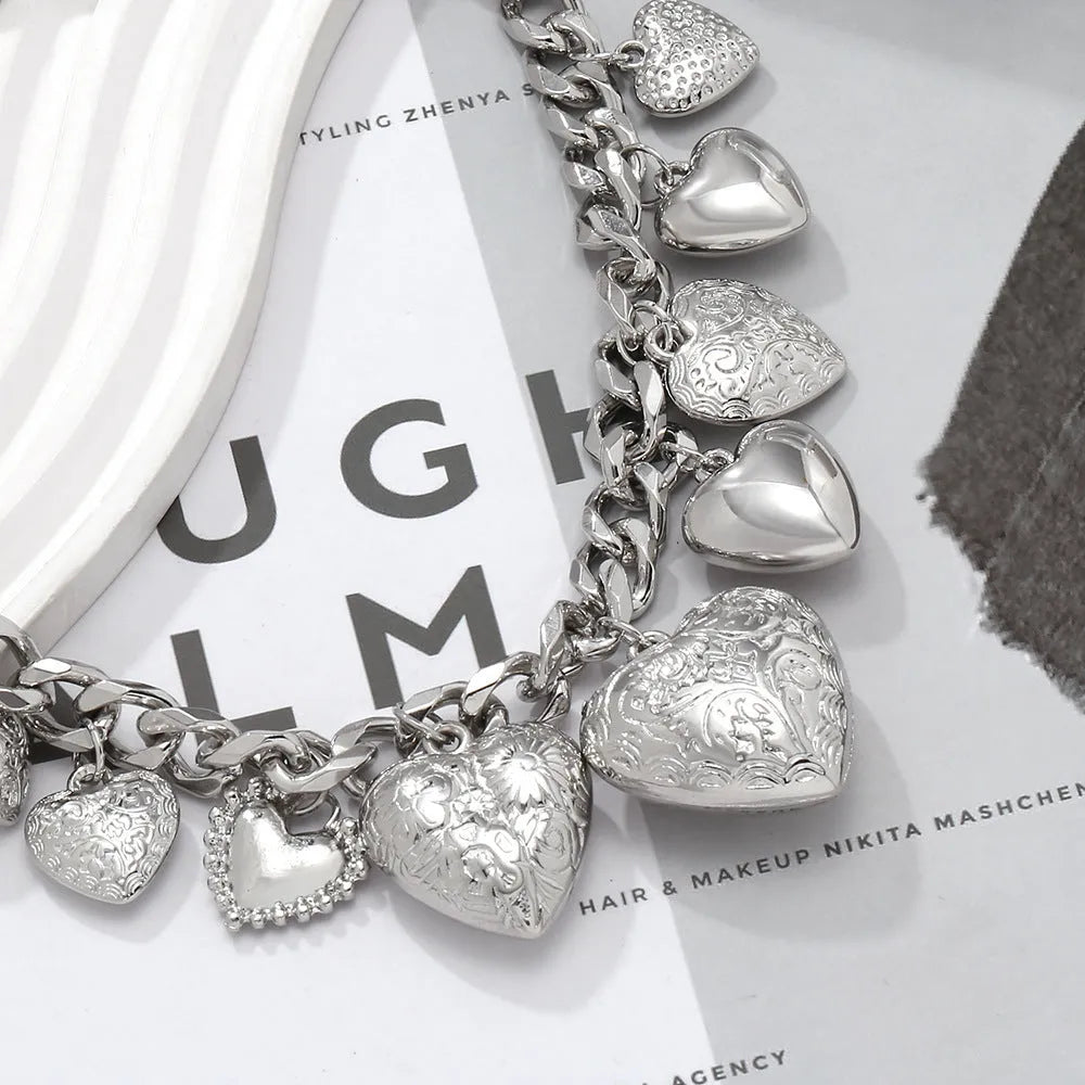 Carved heart-shaped alloy pendant on a metal chain necklace in gold colour.
