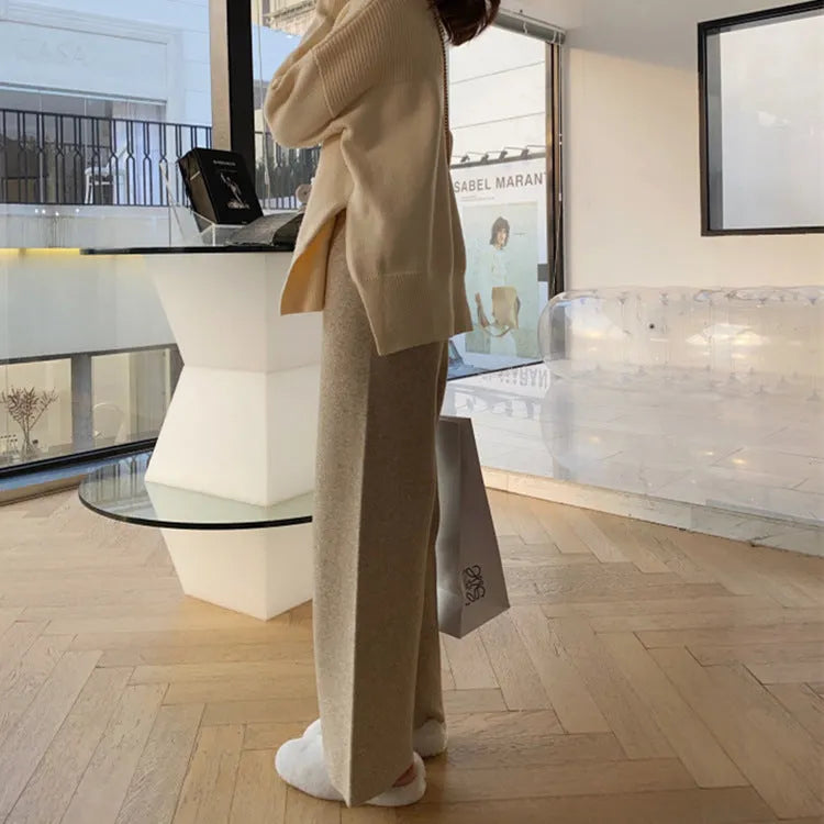 Women's cream white thick knitted wide-leg trousers with a high waist and drooping hem laid flat.