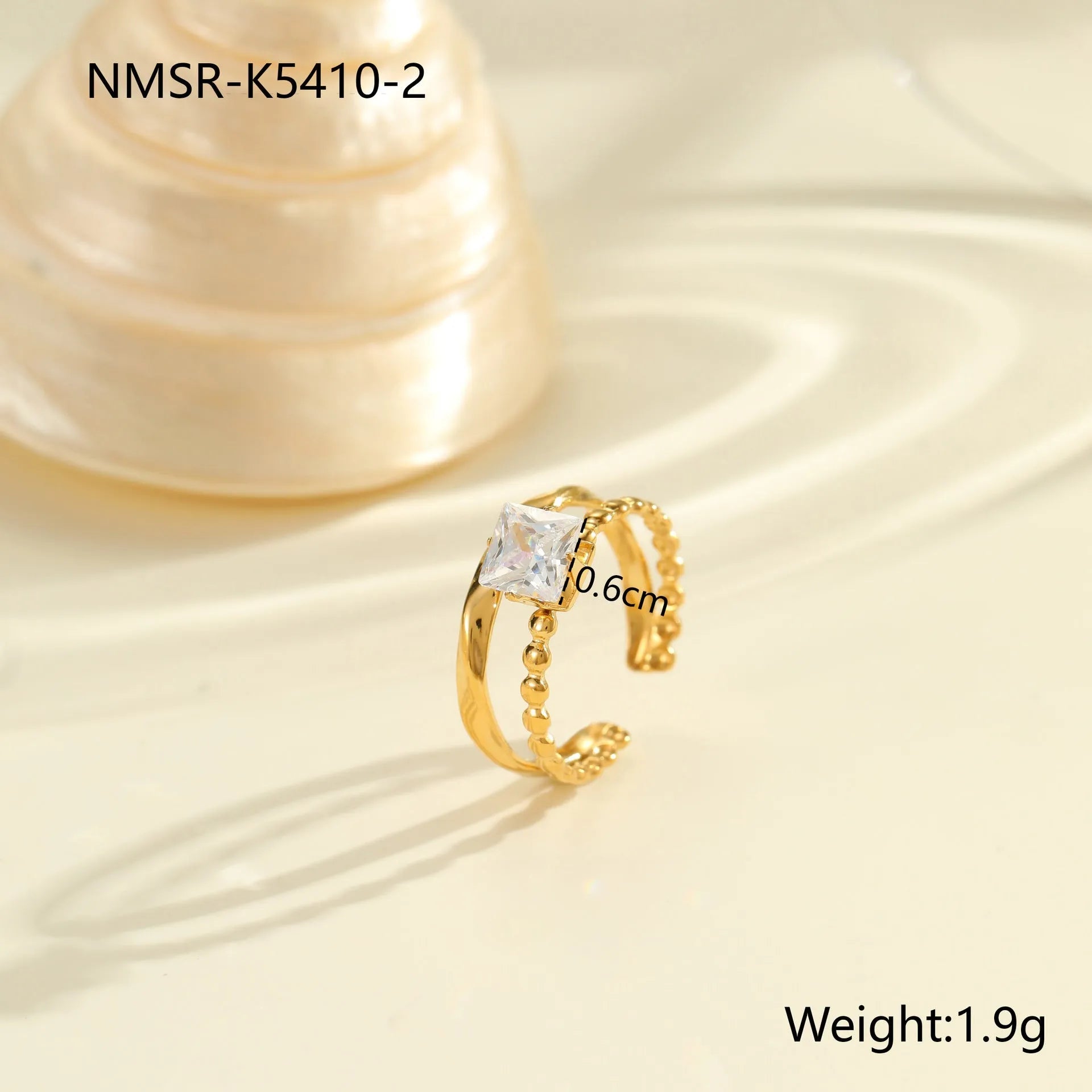 Gold inlaid zircon geometric heart and drop shape stainless steel ring on white background.