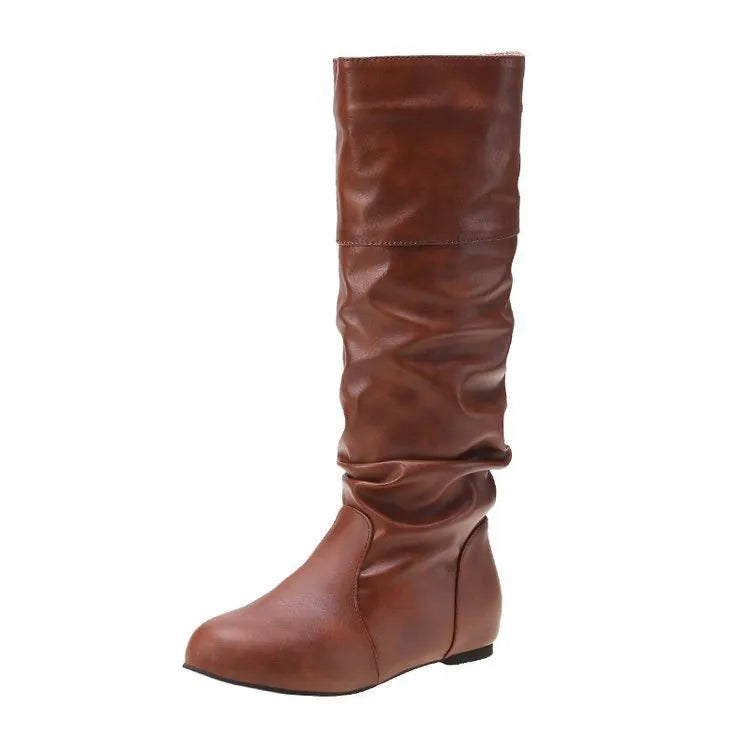 Women's flat slip-on long boots with round toe in black, shown on a foot.
