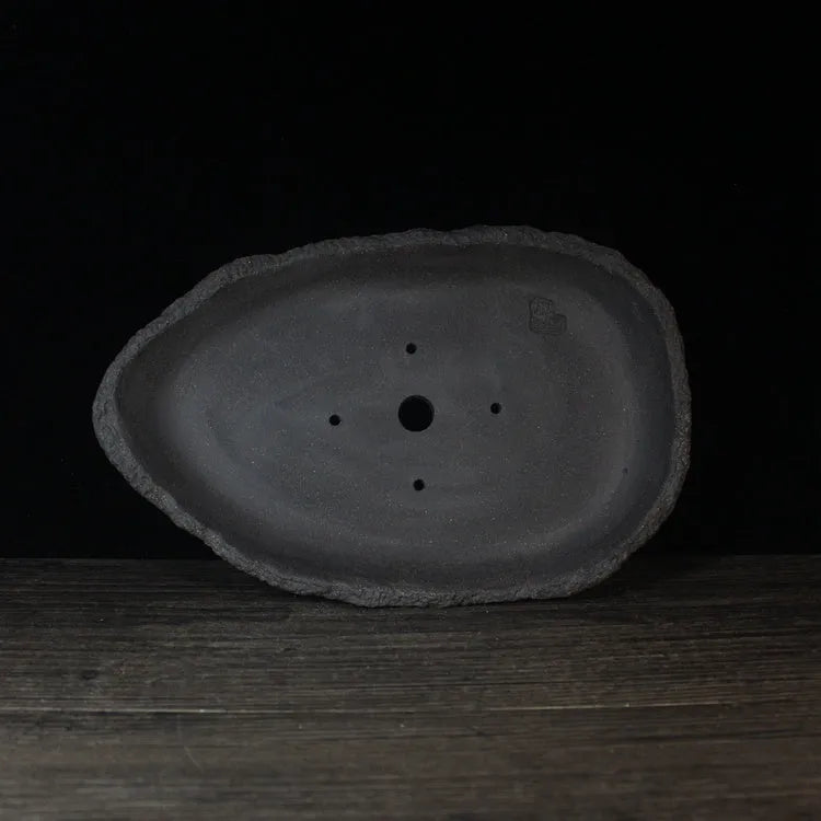 Handmade purple clay flower pot showing unique shape and traditional ceramic texture