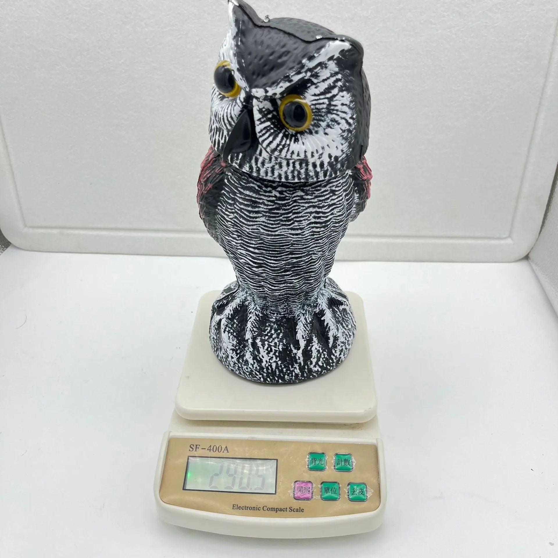 Artificial owl bait ornament with shaking head for garden bird deterrent in outdoor setting