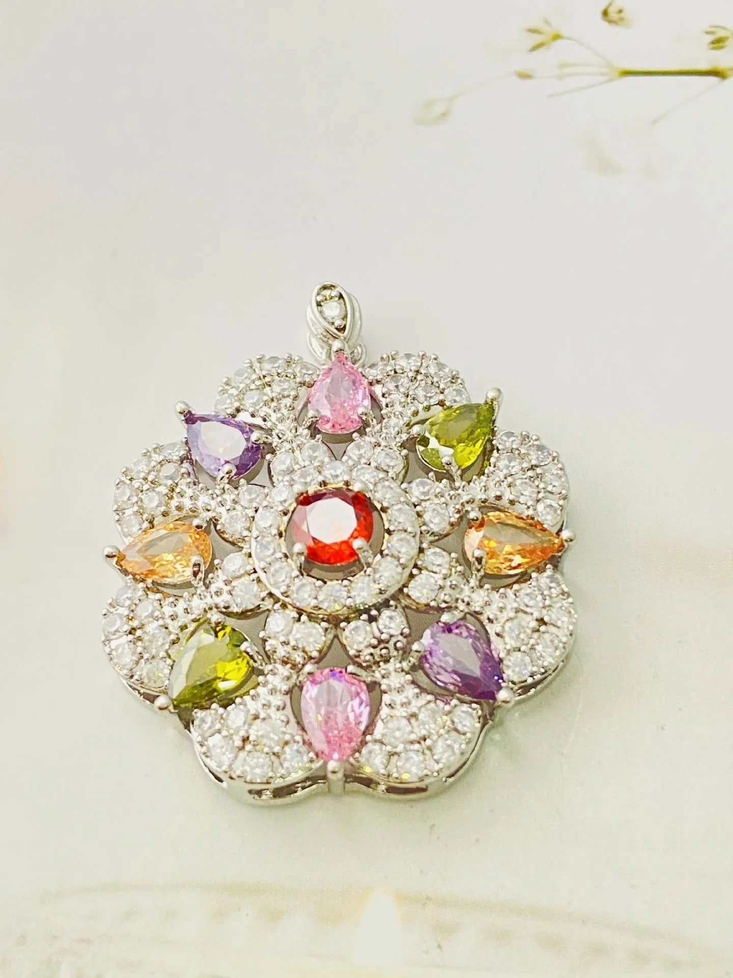 Close-up of a women's flower-shaped zircon pendant necklace in a gold electroplated finish on a model.