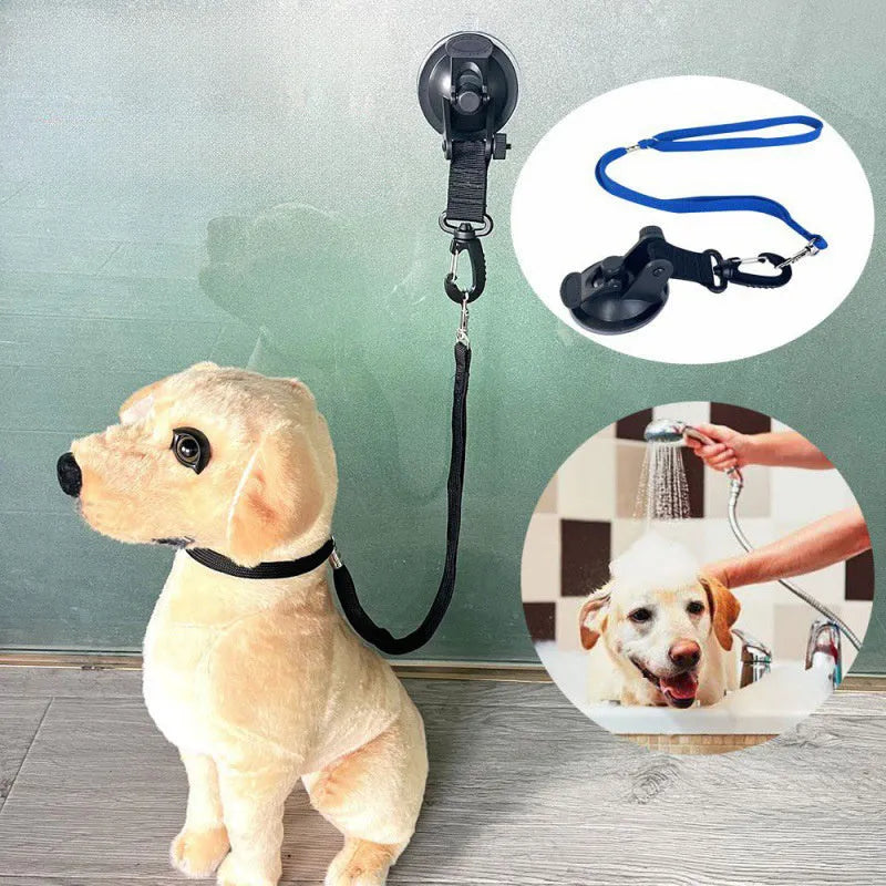 Pet bathing restraint tool with large suction cups, handcuffs, and a connecting rope on a bathroom tile background.