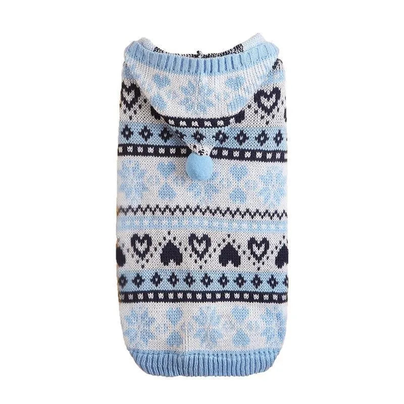 Pink striped dog sweater with snowflake and heart patterns on a small white Bichon