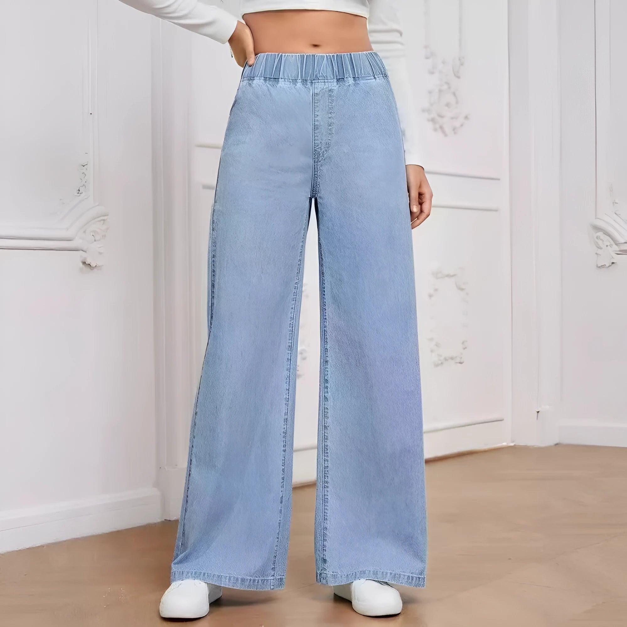 Light blue washed wide-leg denim trousers on a hanger, showing straight cut and zip front.