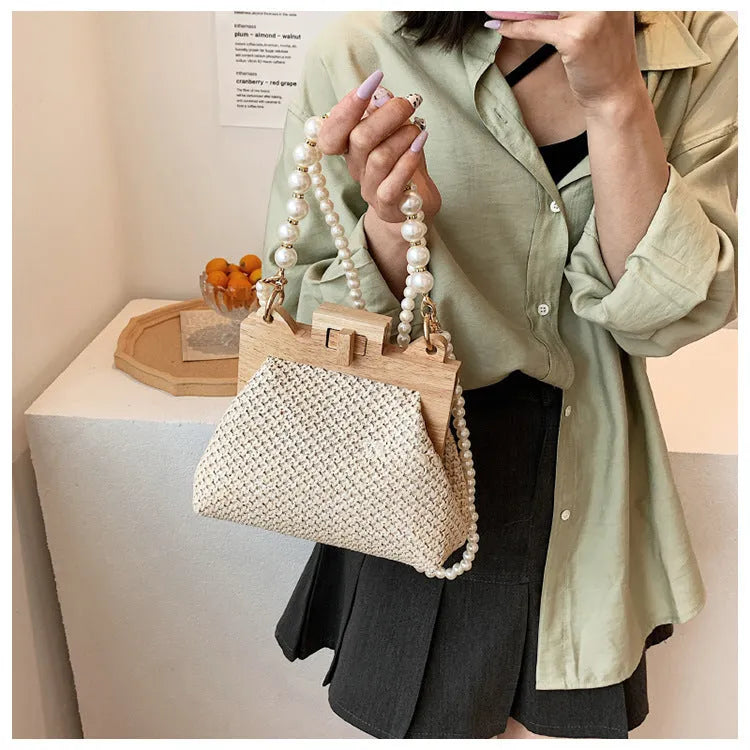Women's straw woven shoulder bag with pearl chain strap in horizontal square shape showing internal organisers