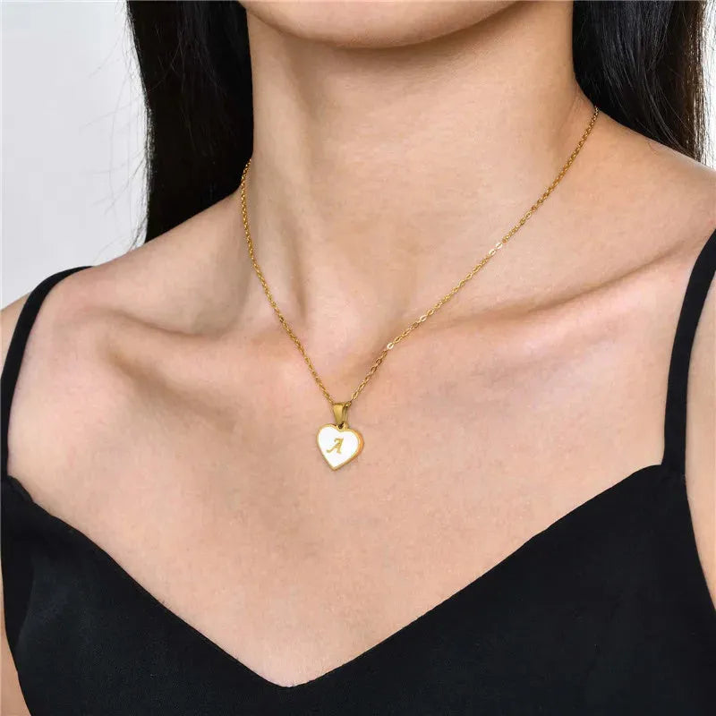 Gold plated heart pendant necklace with white shell centre on a stainless steel chain.