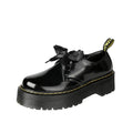 Black thick-soled women's lace-up shoes with ribbon and cross strap detailing on a white background