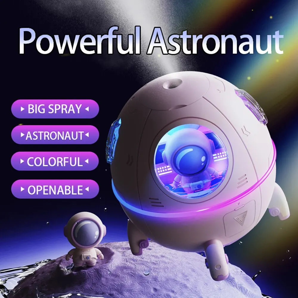 Purple astronaut-shaped USB desktop humidifier with LED light on a desk next to a laptop.