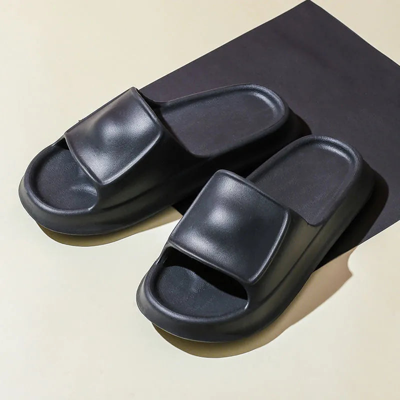 Pair of thick-soled white EVA foam flip-flop slippers on a bathroom floor, showing non-slip tread pattern.