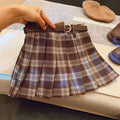 A girls' plaid pleated skirt in an A-line style, shown in a casual setting.