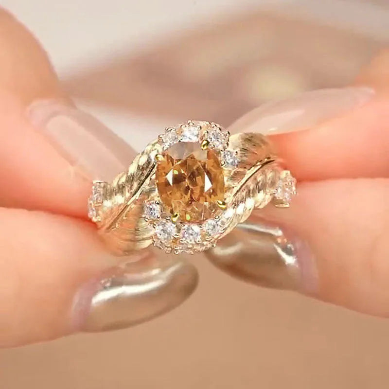 Gold coloured embossed feather ring with geometric design and yellow zircon stone inlays
