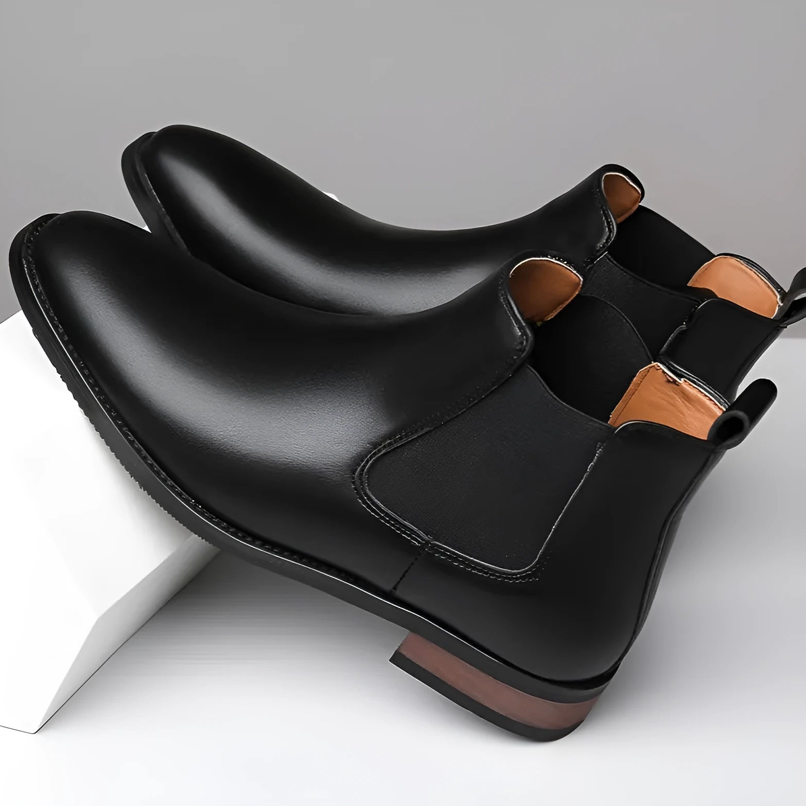 Men's black pointed toe Chelsea boots with a round toe shape and rubber sole.