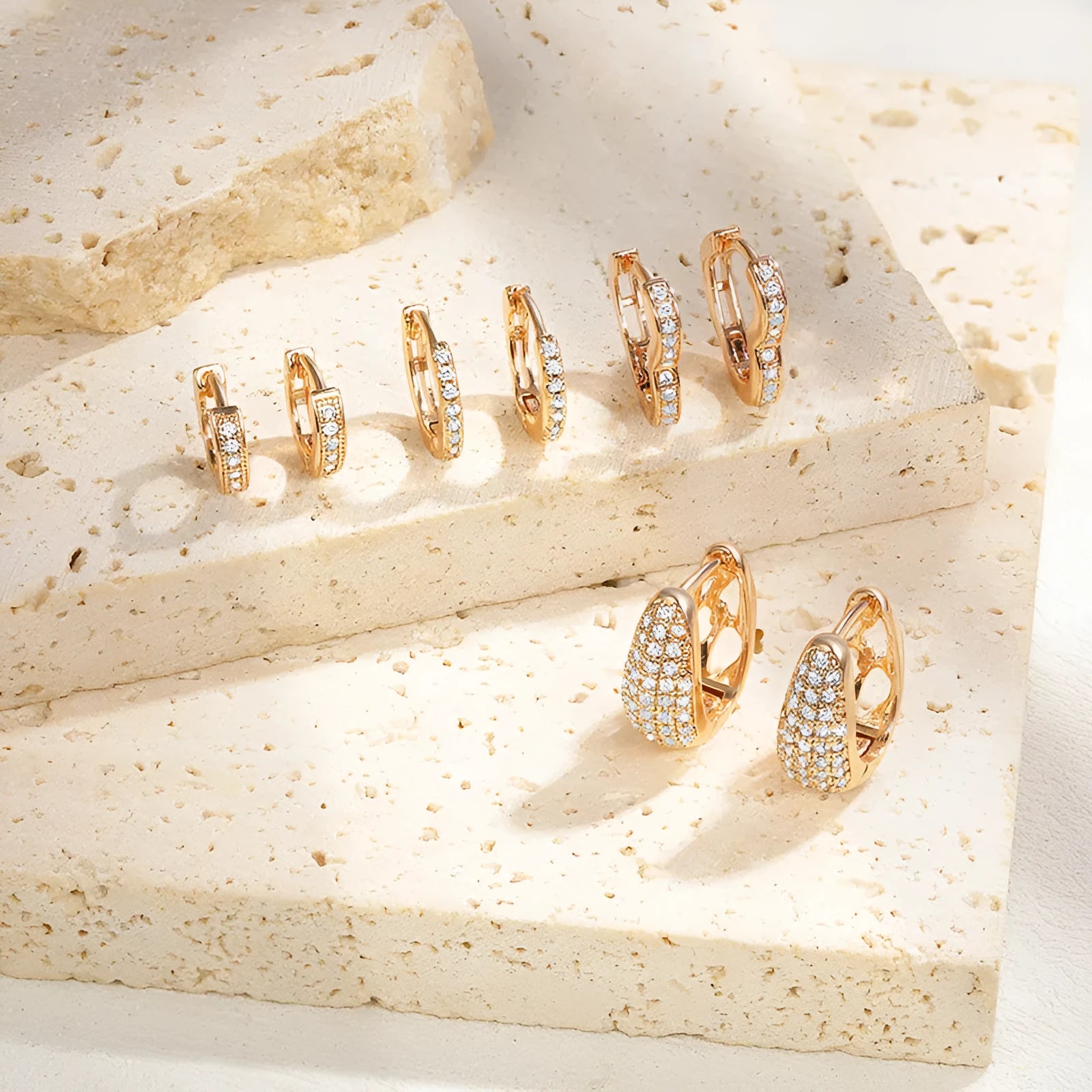 Gold plated brass heart-shaped ear clip earrings with zircon detail on a white background.