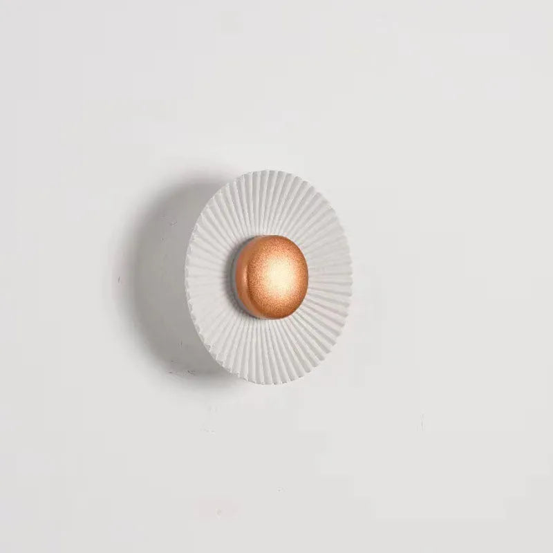 Round aluminium wall lamp mounted on a wall, showing a white and gold two-tone finish.