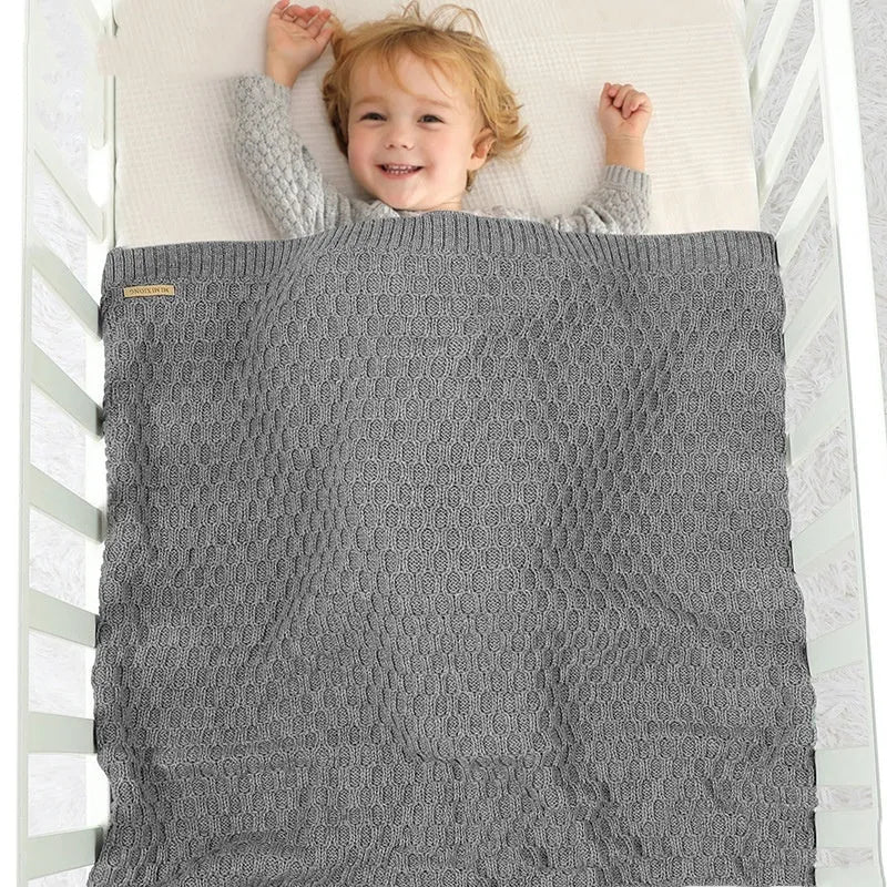 Solid colour infant hug blanket with textured lines, shown in acrylic fabric measuring 70 by 90 cm.