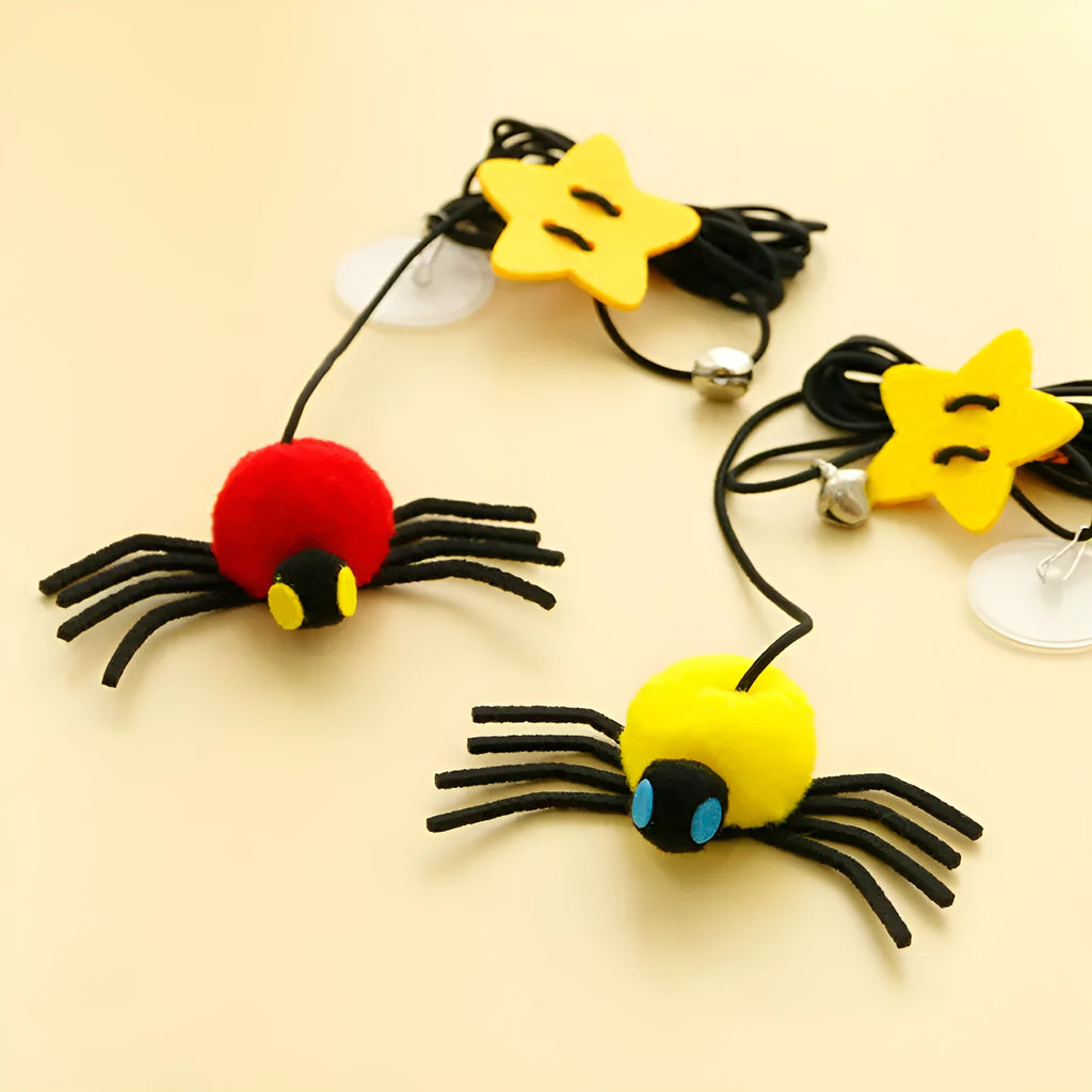 Hanging elastic rope cat toy with feather, bell and spider elements on playing stick in red colour